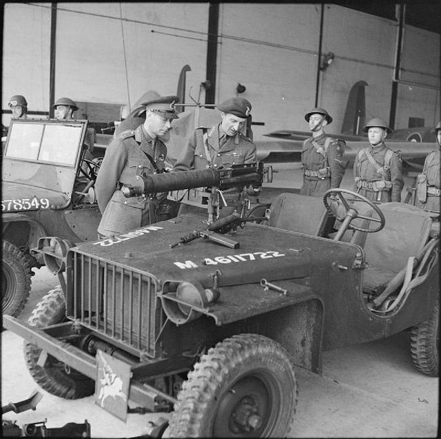 King George VI inspects an airborne jeep fitted with a Vickers machine gun during a visit to the airborne forces in Southern Command, 21 May 1942. Wit