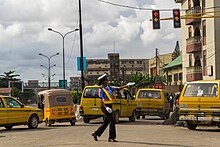 A Nigeria Police Force officer directing traffic at a busy intersection Traffic warder.jpeg