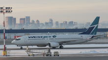 Calgary International Airport is the gateway to Canada's Rocky Mountains. WestJet 737-800 in front of Calgary skyline (Quintin Soloviev).png