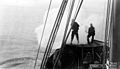 Whalers aboard killer boat firing a harpoon, Alaska, ca 1915 (COBB 54).jpeg