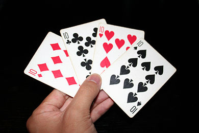 Man de cartas de póker cos catro 10 da baralla.