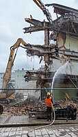 Rang: 31 von 123 Ein Bauarbeiter spritzt Wasser zur Reduzierung der Staubentwicklung bei der Abbrucharbeit