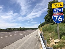 An I-76 trailblazer along the Pennsylvania Turnpike with the black-on-yellow "Toll" sign 2022-07-31 12 16 28 View west along Interstate 76 (Pennsylvania Turnpike Philadelphia Extension) just west of Exit 320 in Charlestown Township, Chester County, Pennsylvania.jpg
