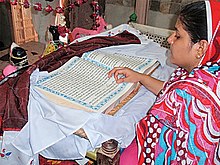 A woman reciting the Guru Granth Sahibat the Sadh Belo temple on the special occasion of the 150th death anniversary of Baba Bhankandi Maharaj