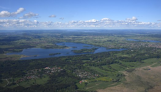 forested hills (Seeleiten) from left to right side of photo and islands in lake Staffelsee.