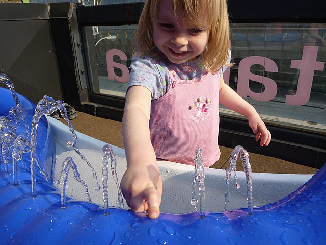 A young musician plays the hydraulophone by pressing on jets of water laid out to a musical scale.