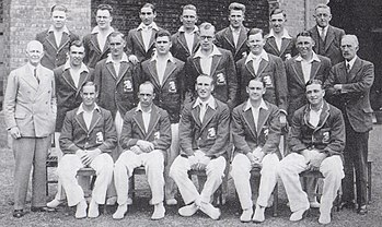 A cricket team arranged in three rows. Seventeen men are dressed as players, the other three men are in suits.