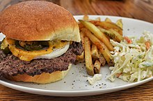 A cheeseburger served with fries and coleslaw Cheeseburger (17237580619).jpg