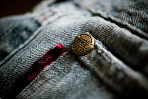 Closeup of a copper rivet on blue jeans.