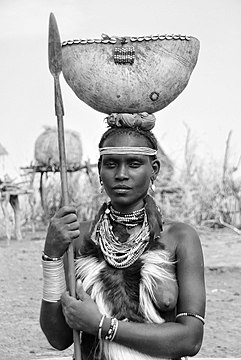 Junge Frau der Dassanetch, Äthiopien, mit Guerezafell als Brustschmuck (undatiert)