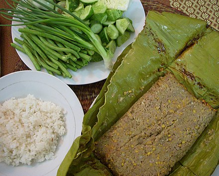 Prahok fried in banana leaves with steamed rice, yardlong beans, cucumbers, spring onions and Thai eggplants.