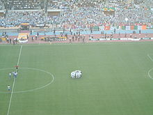 voetballers vormen een cirkel in een stadion