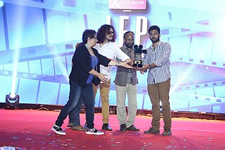 IFP 2015 Winner Vijay Velukutty receiving trophy from Jury Ketan Mehta, Guneet Monga and Raja Sen. IFP 2015 Winner receiving Award.jpg