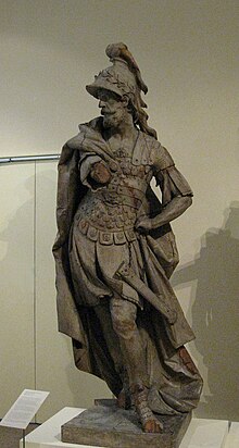 Old and damaged marble statue of a Roman god of war with flowing cloak, big helmet with a plume on top, and armor
