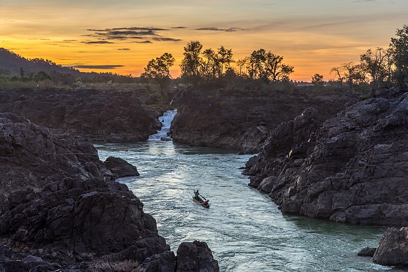 File:Li Phi falls at sunset with orange sky and a fishing boat in Don Khon Si Phan Don Laos.jpg