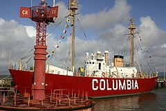 Full-length photograph of the lightship Columbia at dock with a bright red hull and the word "Columbia" in white on the side.