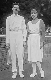 Lenglen and Brugnon posing with rackets on the court in tennis attire
