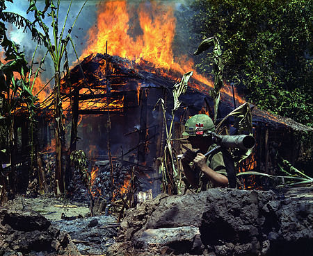Fail:My Tho, Vietnam. A Viet Cong base camp being. In the foreground is Private First Class Raymond Rumpa, St Paul, Minnesota - NARA - 530621 edit.jpg