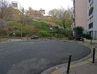 Une placette termine la rue à son extrémité est. En arrière-plan, la butte Bergeyre.