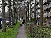 People, walking over the gravel path along the canal Kattenburgervaart; free photo Amsterdam city, Fons Heijnsbroek January 2022