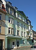 Apartment building in closed development, with shop and boundary wall with built-in coach house and transformer house