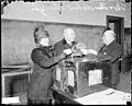 Robert M. Sweitzer, Cook County clerk and wife, handing their ballots to unidentified man.jpg