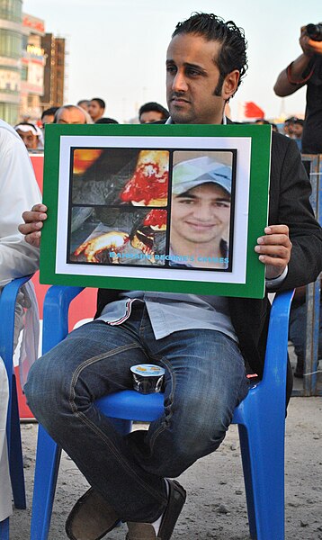 File:Sayed Yousif al-Mahafdha holding image an injured youth during a pro-democracy sit-in in Muqsha'a.JPG