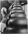 Woman standing next to a wide range of tire sizes required by military aircraft, archiv NARA