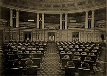 Illustration d'une assemblée avec un parterre de chaises devant une façade avec des piliers.