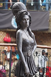 Bronze statue of Winehouse in Camden Town, London unveiled in September 2014 Amy Winehouse Statue, Camden (14946739033).jpg