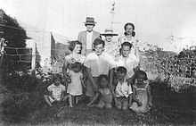 Jacquie Baxter (back right) with her husband (centre), their children (son kneeling in front of him and daughter front right), his brother's family and his parents in circa 1955 Baxter family in the 1950s.jpg