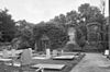 Begroeide ruïne, kerkhof met grafstenen op de voorgrond - Warmond - 20399731 - RCE.jpg