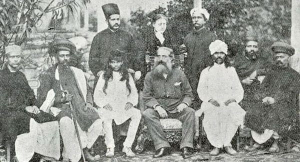 Helena Blavatsky standing behind Henry Steele Olcott (middle seated) and Damodar Mavalankar (seated at his right) in Bombay 1881