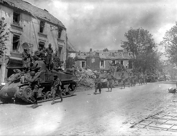 M4 Sherman tanks and infantrymen of the U.S. 4th Armored Division in Coutances