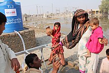Alcune persone raccolgono acqua potabile pulita da un rubinetto nella città di Ghari Kharo, in Pakistan.