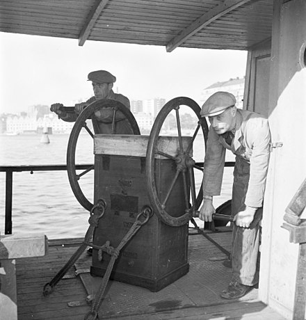 Two men operating a rotary diver's air pump