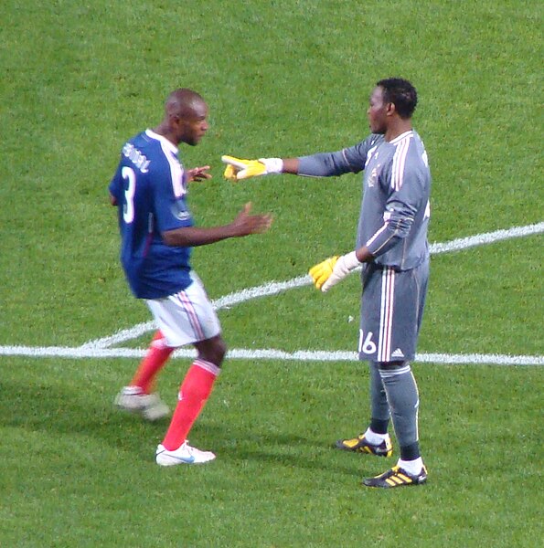 Eric Abidal and Mandanda (right) playing for France in 2010