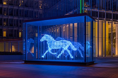Blue neon lighting, first used in commercial advertising, is now used in works of art. This is Zwei Pferde für Münster (Two horses for Münster), a neon sculpture by Stephan Huber (2002), in Munster, Germany.