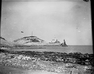 Mumbles lighthouse and sailing boat at Bracelet bay