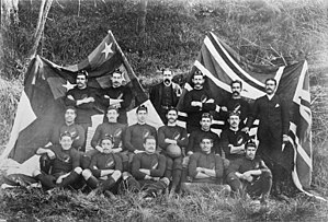 Foto di giocatori e dirigenti della squadra, tutti seduti o in piedi, in tre file, che indossano le maglie da gioco con berretti o abiti da cerimonia.