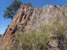 Pilar Formation outcrop with white metatuff beds. Dating of these beds provided some of the first evidence for the Picuris orogeny. Pilar Formation outcrop.jpg