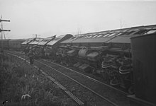 Railway engine and carriages on their sides on the track after being involved in a collision at Tamaree, October 1947