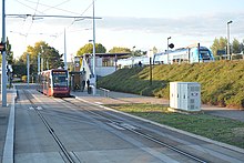Une rame de tramway et un TER en correspondance