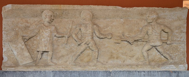 File:Relief depicting two gladiators fighting while a referee looks on, found in the gladiator graveyard at Ephesus, Ephesus Museum, Turkey (17277590191).jpg