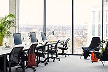 gran oficina de planta abierta con ventanas del piso al techo