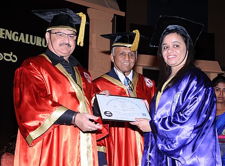 A doctor receiving her PhD degree during a graduation ceremony.