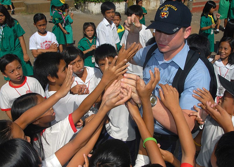 File:US Navy 071016-N-6710M-004 Information Systems Technician Seaman Drew T. Spaeth hands out candy to the students of Gordon Heights Elementary School while conducting a community relations project in the Republic of Philippines.jpg