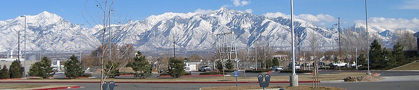 The Salt Lake Valley, from left to right shown are Twin Peaks (11,489 ft or 3502 m), Lone Peak (11,253 ft or 3430 m), and Mount Timpanogos (11,722 ft or 3573 m) covered in clouds on the far right upper corner. Twin Peaks has a rise of 7,099 ft (2,164 m) or 2164 m from the valley floor. The valley floor depicted is almost completely urbanized.