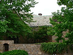 Goodhue's evocative Wolf's Head Society building, shown behind its high stone enclosure. Yale Wolf's Head walled distance.JPG