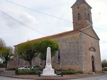 Una iglesia de piedra con un campanario cuadrado sobre el porche clásico con frontón.